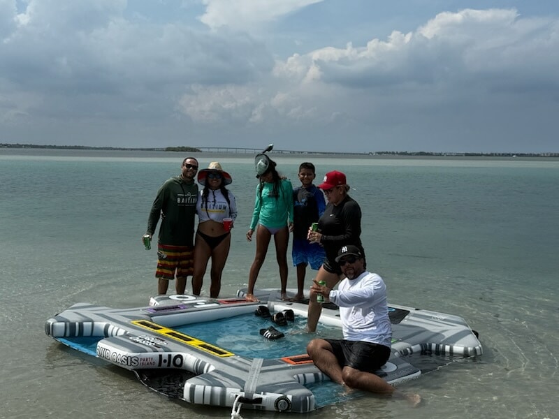 Kids having fun on the oversized lounge raft during a Treasure Coast boat trip